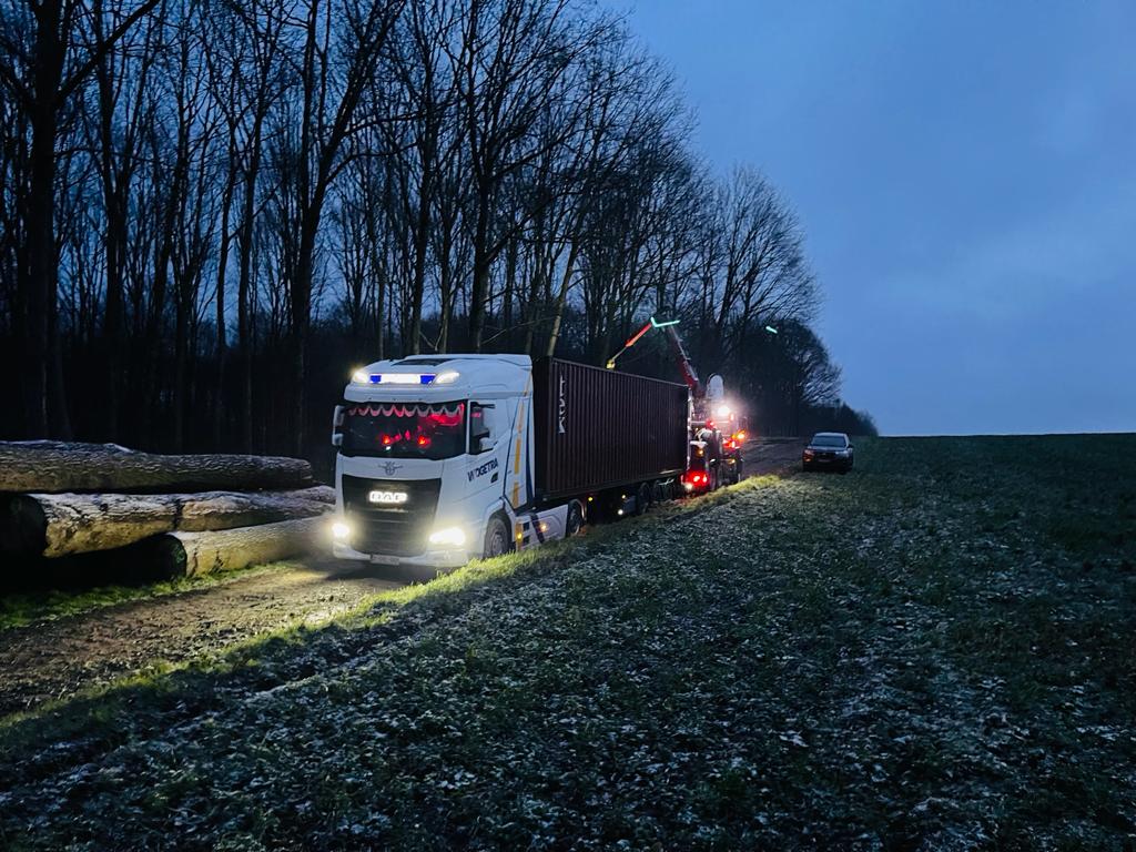Wogetra trekker met zeecontainer op een landweg bij dageraad